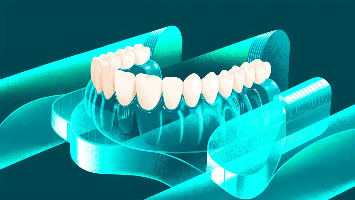 A digitally designed denture on screen next to a 3D printer